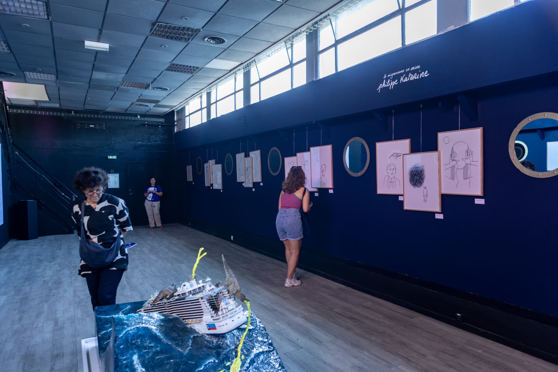 Salle d'exposition bleue avec les dessins de Philippe Katerine