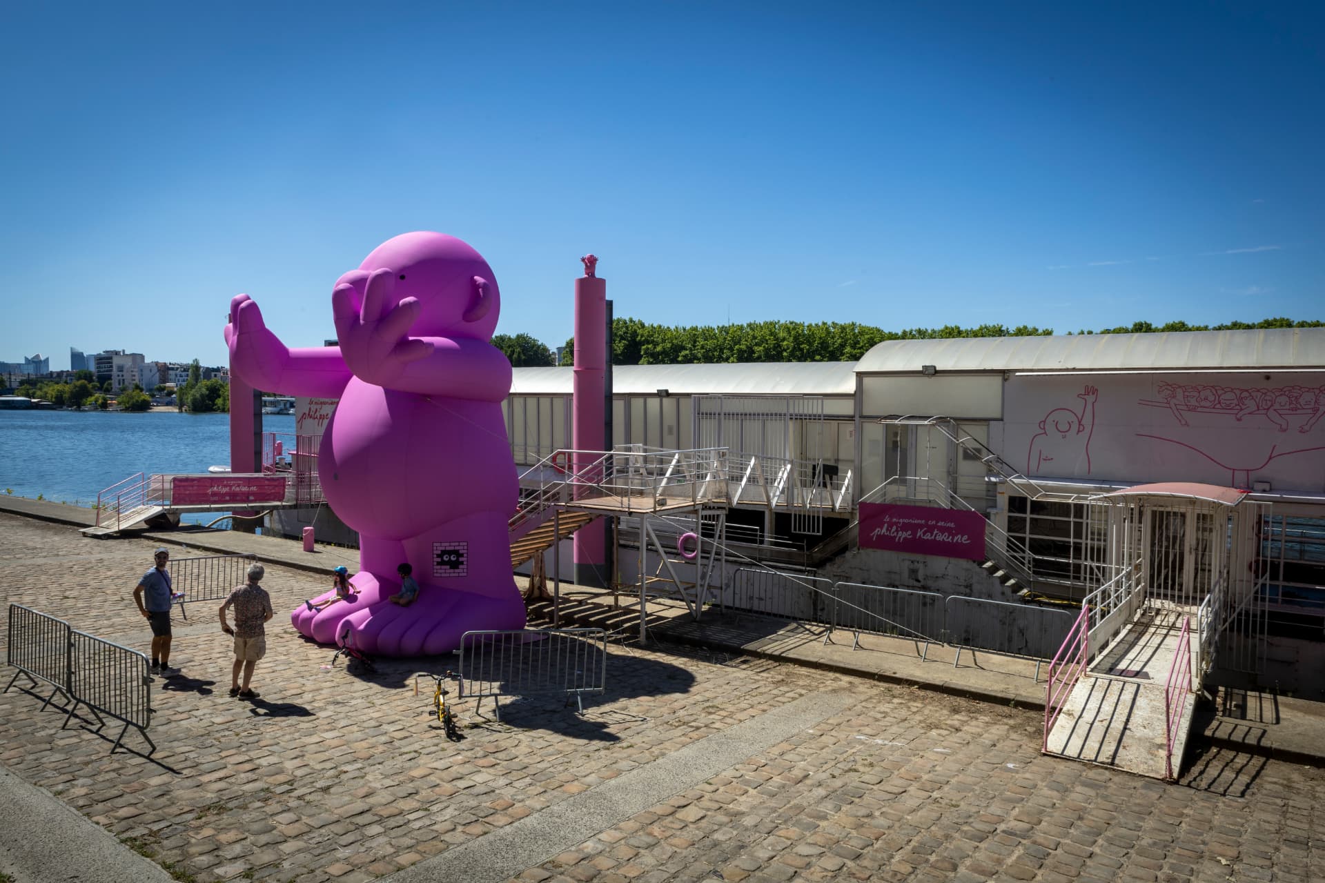 Sculpture gonflable rose de Philippe Katerine sur les quais devant la péniche