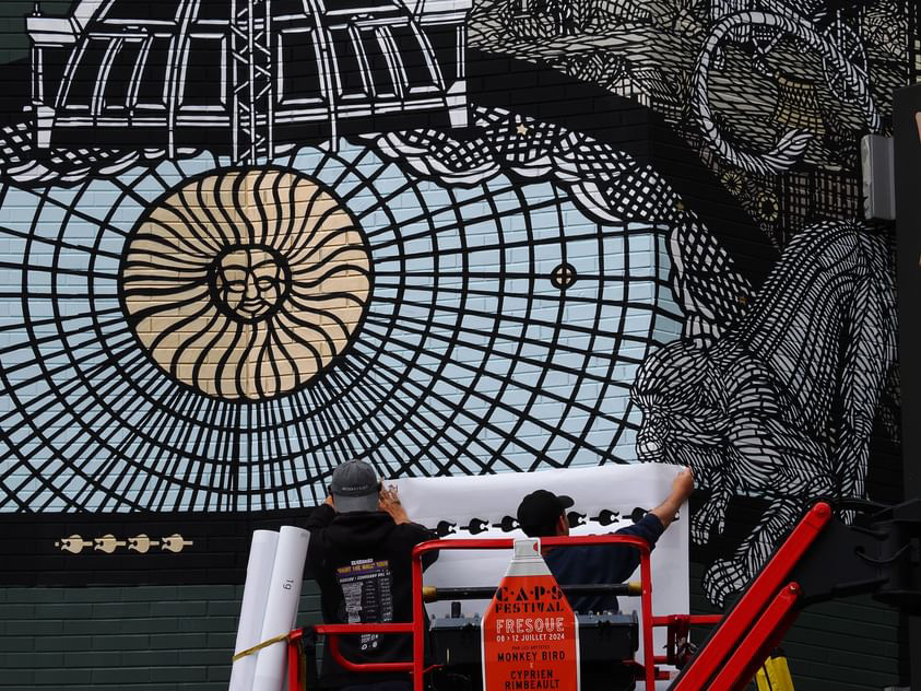 Artistes en train de réaliser la fresque depuis la nacelle